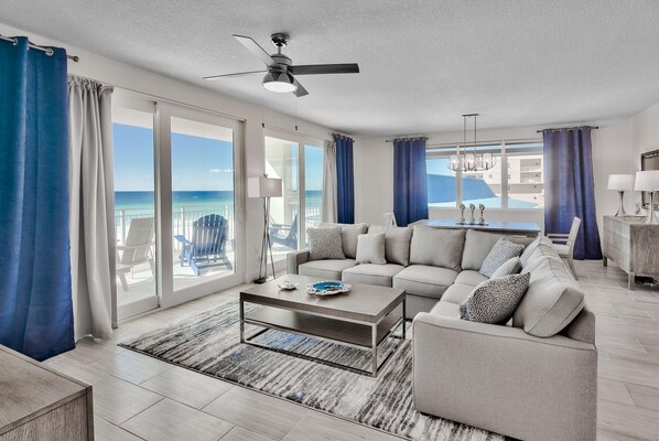 A modern living room with a sofa, coffee table, and a view of the ocean.