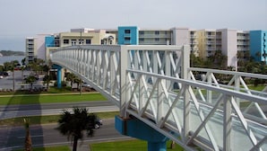Eine moderne Fußgängerbrücke, die zwei Bereiche mit Gebäuden im Hintergrund verbindet.