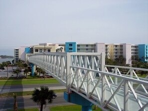 Un ponte pedonale dal design moderno che collega due aree sullo sfondo delle quali si vedono edifici.