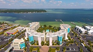 Et højt hotel med flere altaner, en central gårdsplads og udsigt over den omkringliggende lysthavn og ocean.