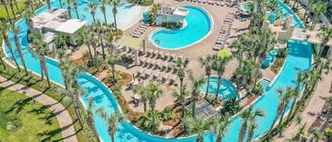 Relax by the resort's large, winding pool surrounded by palm trees and sun loungers.