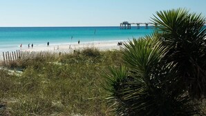 A beach with people walking and a pier in the background. - Heron 604-Watch for Dolphins from your balcony!  3 BR Condo with Great Views (Fort Walton Beach)
