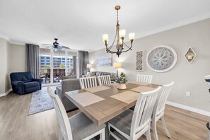 Ein modernes Wohnzimmer mit Essbereich, Deckenventilator und Blick ins Freie.