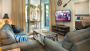 A modern living room with grey sofas, a wooden coffee table, and a flat-screen TV.
