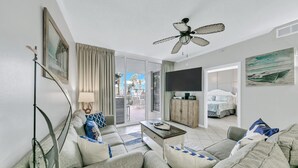 Een moderne woonkamer met een bank, salontafel en plafondventilator.