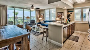 A spacious living area with a dining table, sofa, and kitchen island.