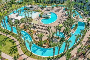 An aerial view of a resort with multiple swimming pools, sun loungers, and palm trees. - SANDPIPER PH02- 3BR PENTHOUSE @ DESTIN WEST-WHAT A VIEW!! (Fort Walton Beach)