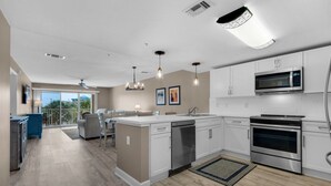 A modern kitchen with white cabinets, stainless steel appliances, and a central island.