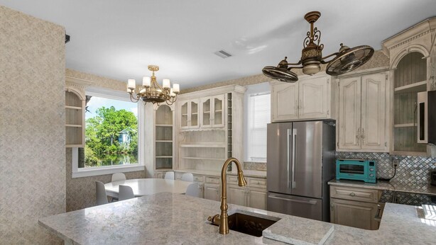 A kitchen with a central island, stainless steel appliances, and a view of greenery outside. - BUNGALOWS @ SEAGROVE! Near the Beach!!  Community Pool!! (Santa Rosa Beach)