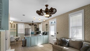 A modern kitchen with a central island, white cabinetry, and a dining area with a white table and chairs. - BUNGALOWS @ SEAGROVE! Near the Beach!!  Community Pool!! (Santa Rosa Beach)