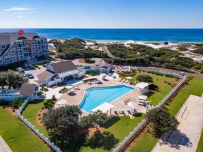 Ein Resort mit Pool, Sitzgelegenheiten im Freien und Blick auf den Ozean.