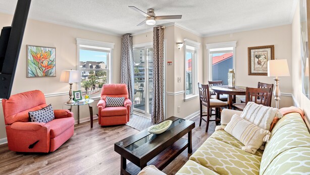 A living room with a sofa, two armchairs, a coffee table, and a dining area with a table and chairs. - Newly renovated, 3rd floor, ocean view condo + Free Attraction Tickets! (North Myrtle Beach)
