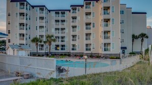 A multi-story hotel with a swimming pool and outdoor seating area. - Newly renovated, 3rd floor, ocean view condo + Free Attraction Tickets! (North Myrtle Beach)