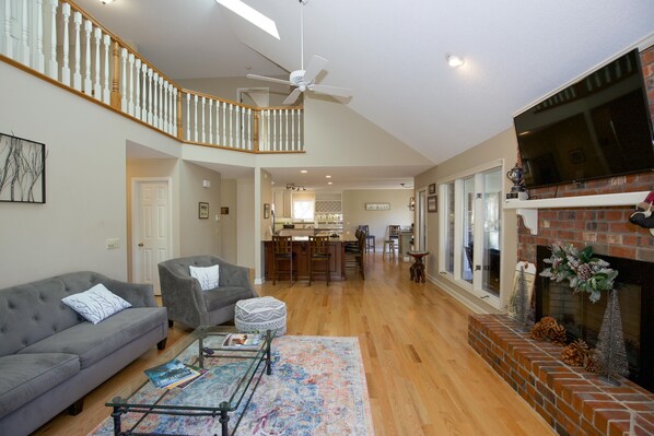 A spacious living room with a grey sofa, a coffee table, and a fireplace. - Unwind at Cathedral Cottage: The Perfect Escape (Pinehurst)