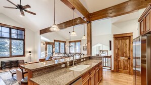 A spacious kitchen with granite countertops, wooden cabinets, and a large island with a sink. - Retreat at Shock Hill Home: Walk to Gondola (Breckenridge)