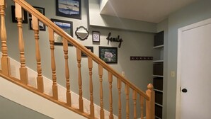 A staircase with wooden balusters leading to a landing with framed pictures and a 'family' sign. - Sugar Ski Comfort Efficiency (with Loft) - Unit 10-303 (Sugar Mountain)