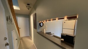 A hallway leading to a kitchen with a long countertop, a sink, and a refrigerator. - Sugar Ski Comfort Efficiency (with Loft) - Unit 10-303 (Sugar Mountain)