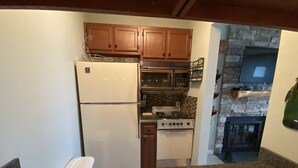 A kitchen with wooden cabinets, a white refrigerator, a stove, and a microwave. - Sugar Ski Comfort Efficiency (with Loft) - Unit 10-303 (Sugar Mountain)