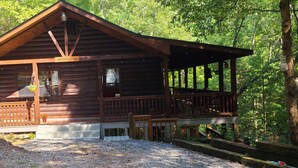 A wooden cabin with a porch and a sign that reads "Welcome to Green Country." - "  Lazy Bears Cabin" Located in Cherry Log
Highly Rated  overall by Guest (Blue Ridge)