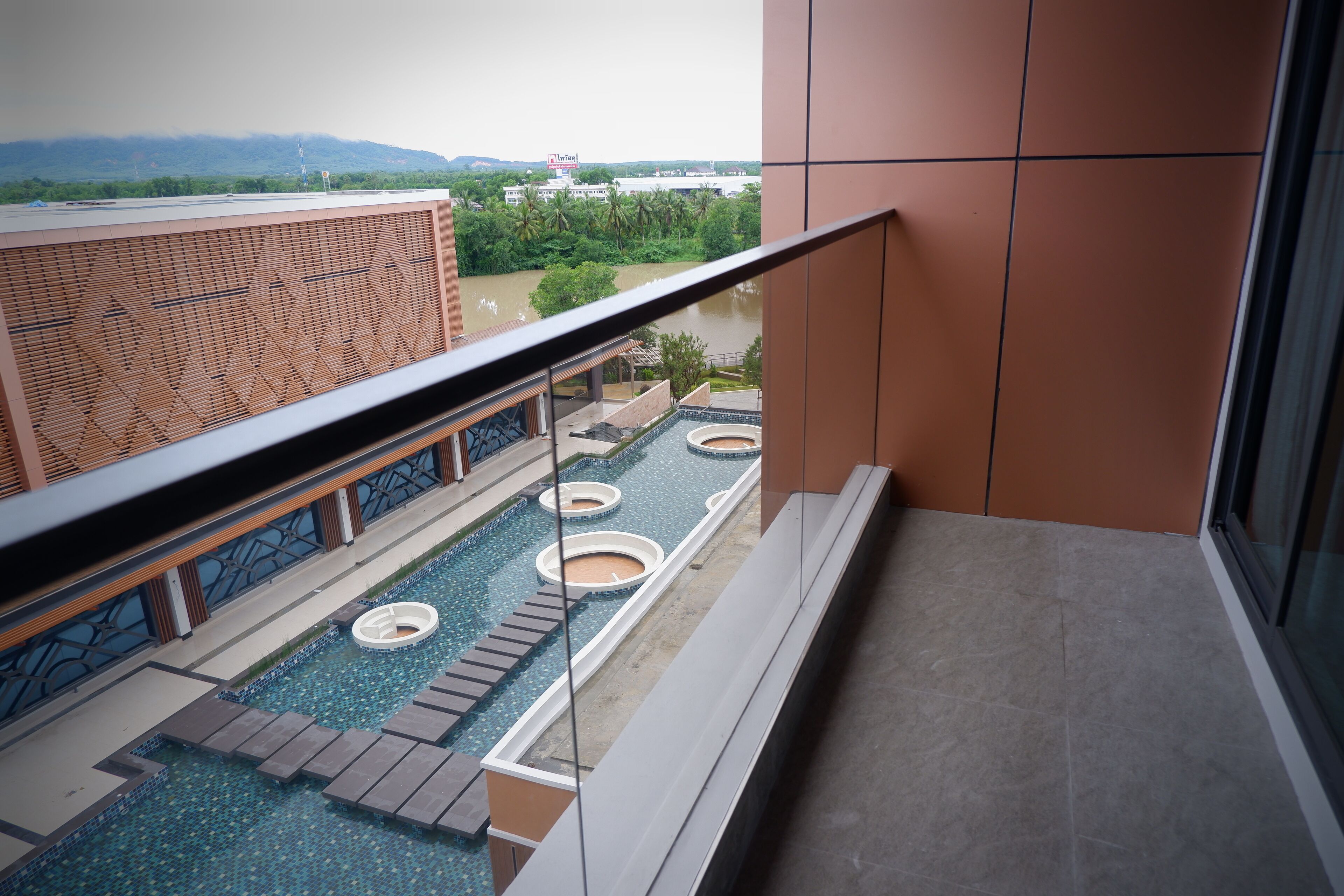 Un balcon avec vue sur une piscine et une rivière.