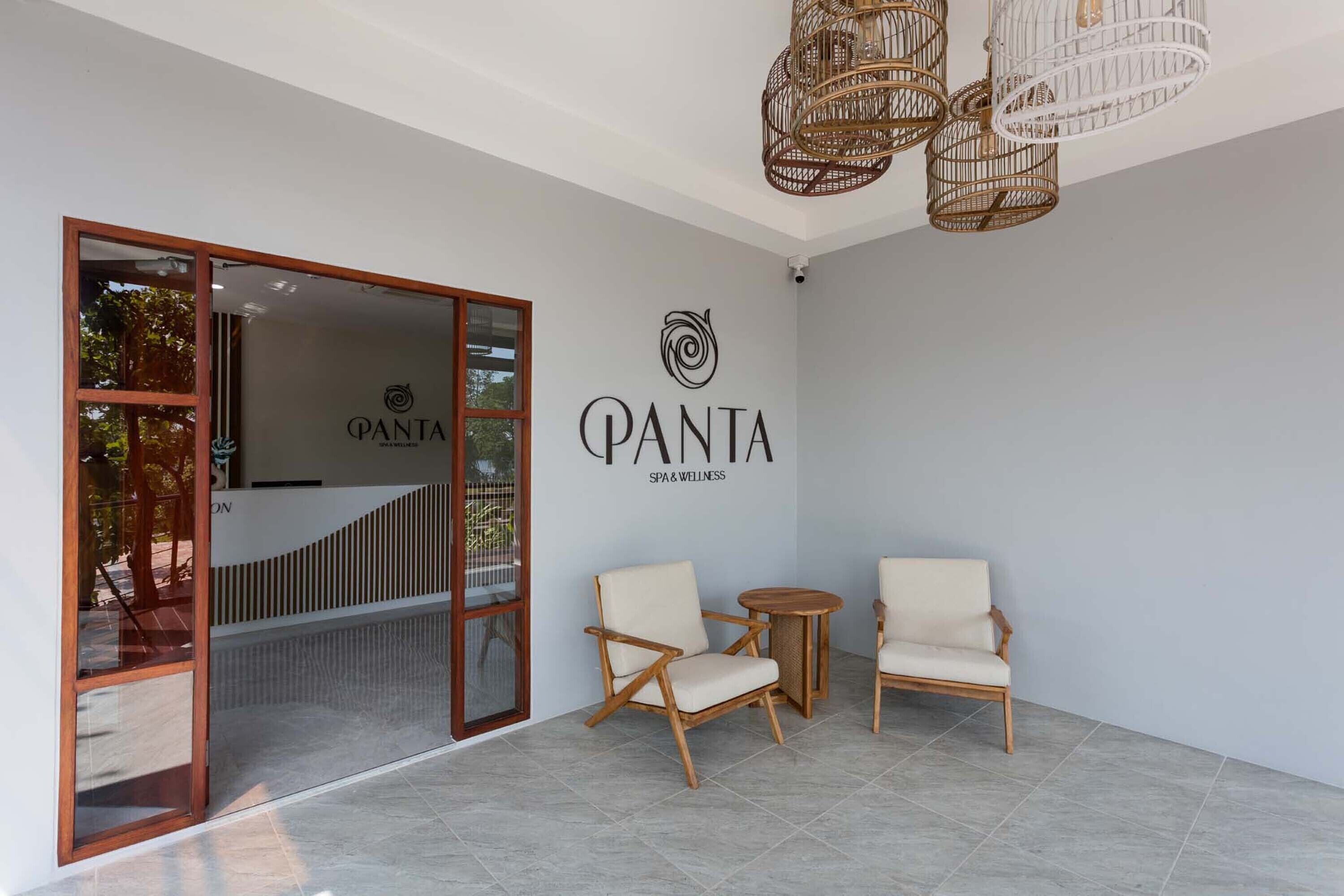 A spa area with a reception desk, a wall-mounted logo, and two chairs.