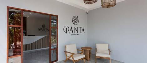 A spa area with a reception desk, a wall-mounted logo, and two chairs.