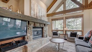 A cozy living room with a stone fireplace, a flat-screen TV, and comfortable seating. - Luxury 4 Bed Pines Townhome Amongst The Peace And Quiet 4 Bedroom Townhouse by RedAwning (Avon)