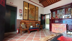 Una camera tradizionale con pavimento in piastrelle, mobili in legno e opere d'arte che riflettono la cultura locale.
