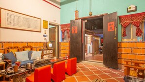 L'interno di un ristorante cinese tradizionale, con pareti in piastrelle arancioni, arredi in legno e tocchi di rosso.