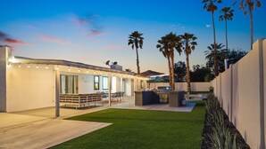 A modern outdoor patio area with a seating area, a barbecue station, and a well-maintained lawn. - Modern Retreat Minutes from Shopping Dining & Golf (Scottsdale)