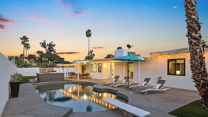 A modern outdoor pool area with lounge chairs and a well-lit patio. - Modern Retreat Minutes from Shopping Dining & Golf (Scottsdale)