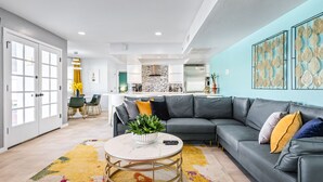 A modern living room with a grey sectional sofa, a round coffee table with a plant, and a colorful rug. - Modern Retreat Minutes from Shopping Dining & Golf (Scottsdale)