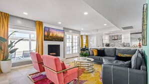 A modern living room with a sofa, chairs, a fireplace, and a kitchen area. - Modern Retreat Minutes from Shopping Dining & Golf (Scottsdale)
