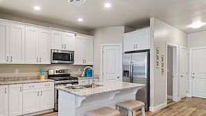 A modern kitchen with white cabinets, stainless steel appliances, and a granite countertop. - Sunshine Seekers, PICKLEBALL COURTS, 2 ARCADE GAMES! (Washington)