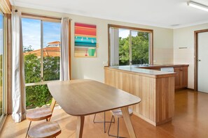 Una cocina moderna con una isla de madera, ventanas amplias y vistas al vecindario.