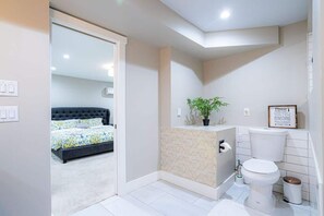 A modern bathroom with a toilet, sink, and shower area. - Fremont Haven: Bright, Comfortable & Central (Seattle)