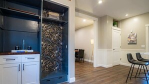 Una cocina moderna con muebles oscuros, un salpicadero estampado y un comedor con mesa y sillas.