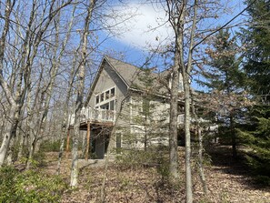 Un chalet rustique en rondins de bois, entouré d’arbres.