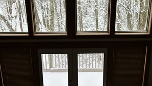 A room with a large window overlooking a snowy forest.