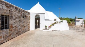A white building with a stone facade and a small entrance. - Il Trullo di Erna by BarbarHouse (Ostuni)