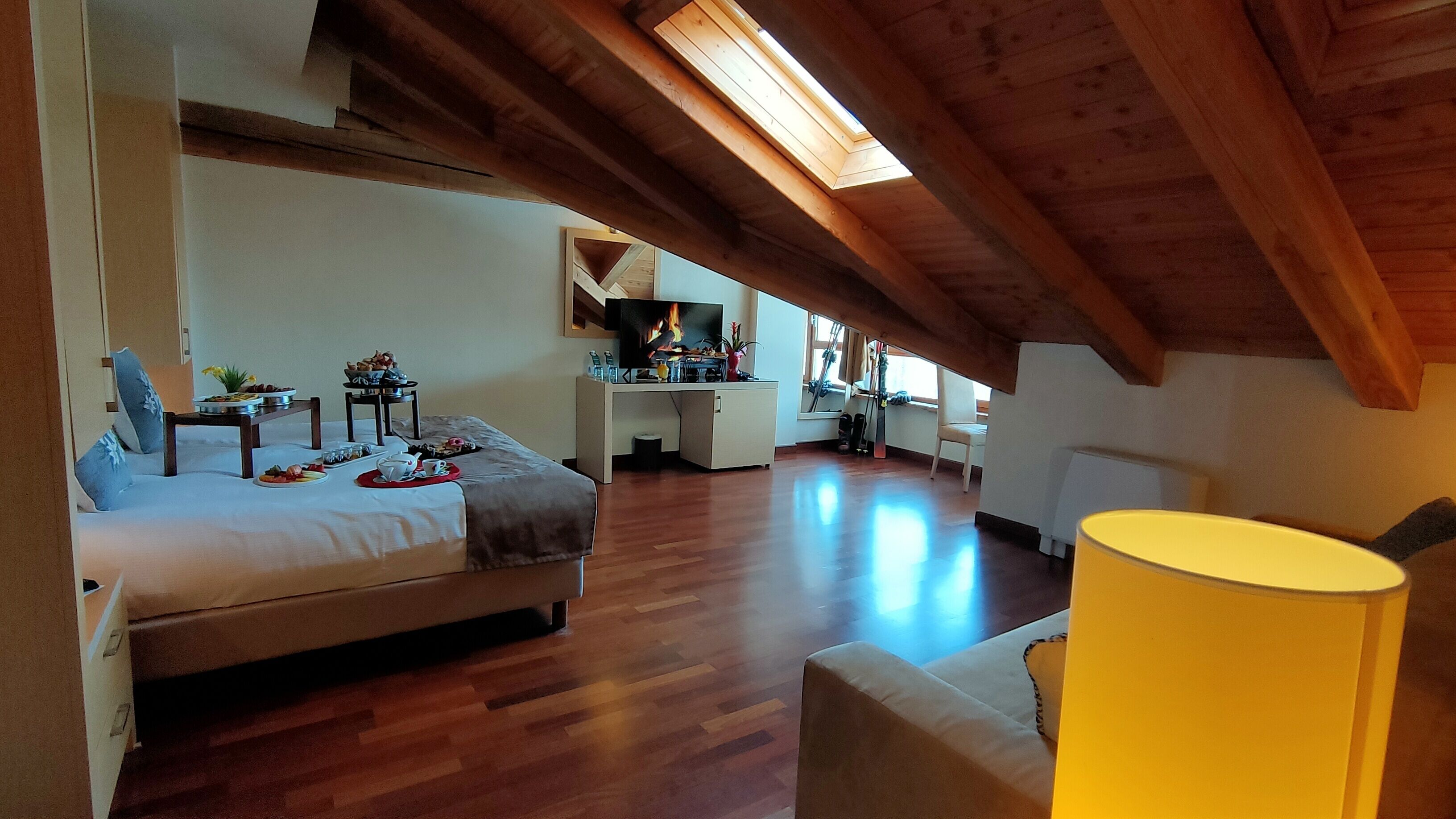 Ein geräumiges Schlafzimmer im Loft-Stil mit einem großen Bett, einem Schreibtisch und einer Essecke.