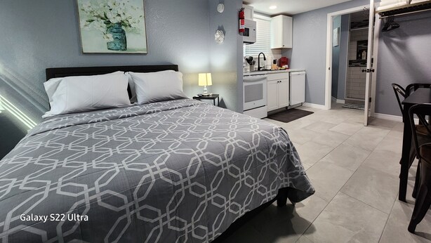 Une chambre dotée d’un lit Galaxy S22 Ultra, d’une kitchenette et d’une salle de bain.