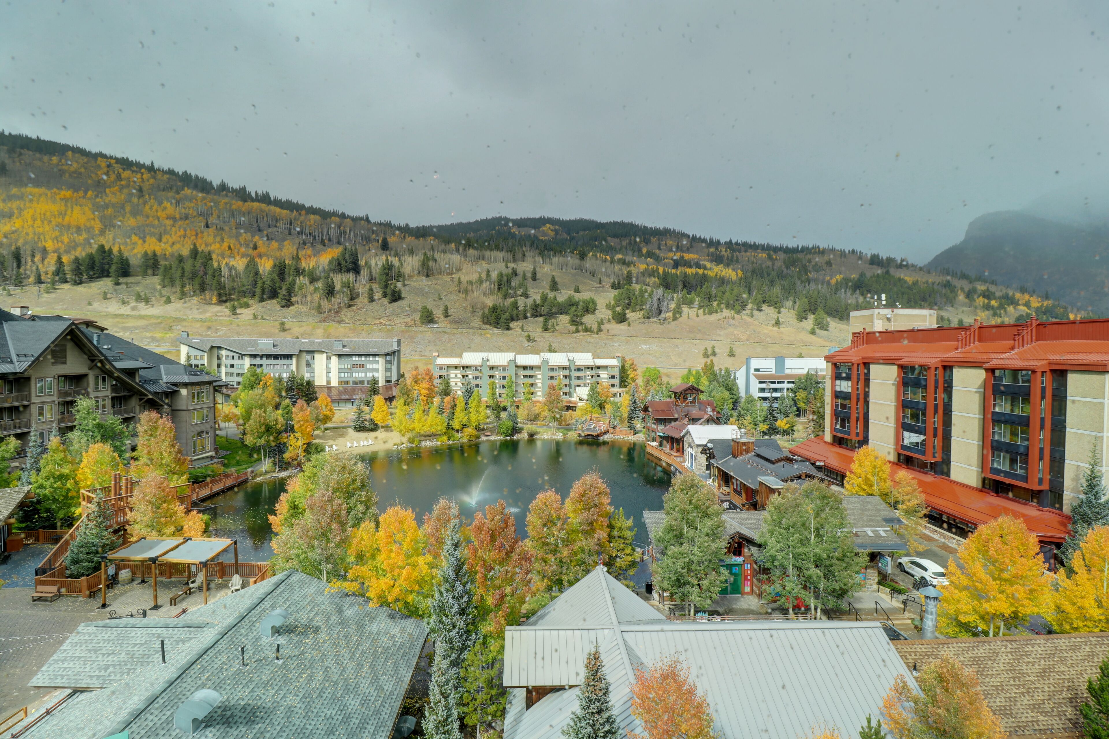 Un hôtel avec vue sur un lac et sur les couleurs automnales des arbres.