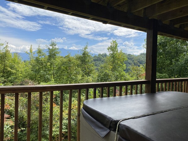 Eine Holzterrasse mit Blick auf Wald und Berge.
