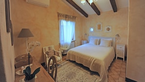 A bedroom with a bed, bedside tables, a chair, a desk, and a lamp. - Luxury Country House in Tuscany (Semproniano)