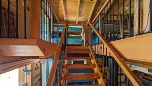 Una escalera de madera con barandilla de vidrio que conduce a un nivel superior.