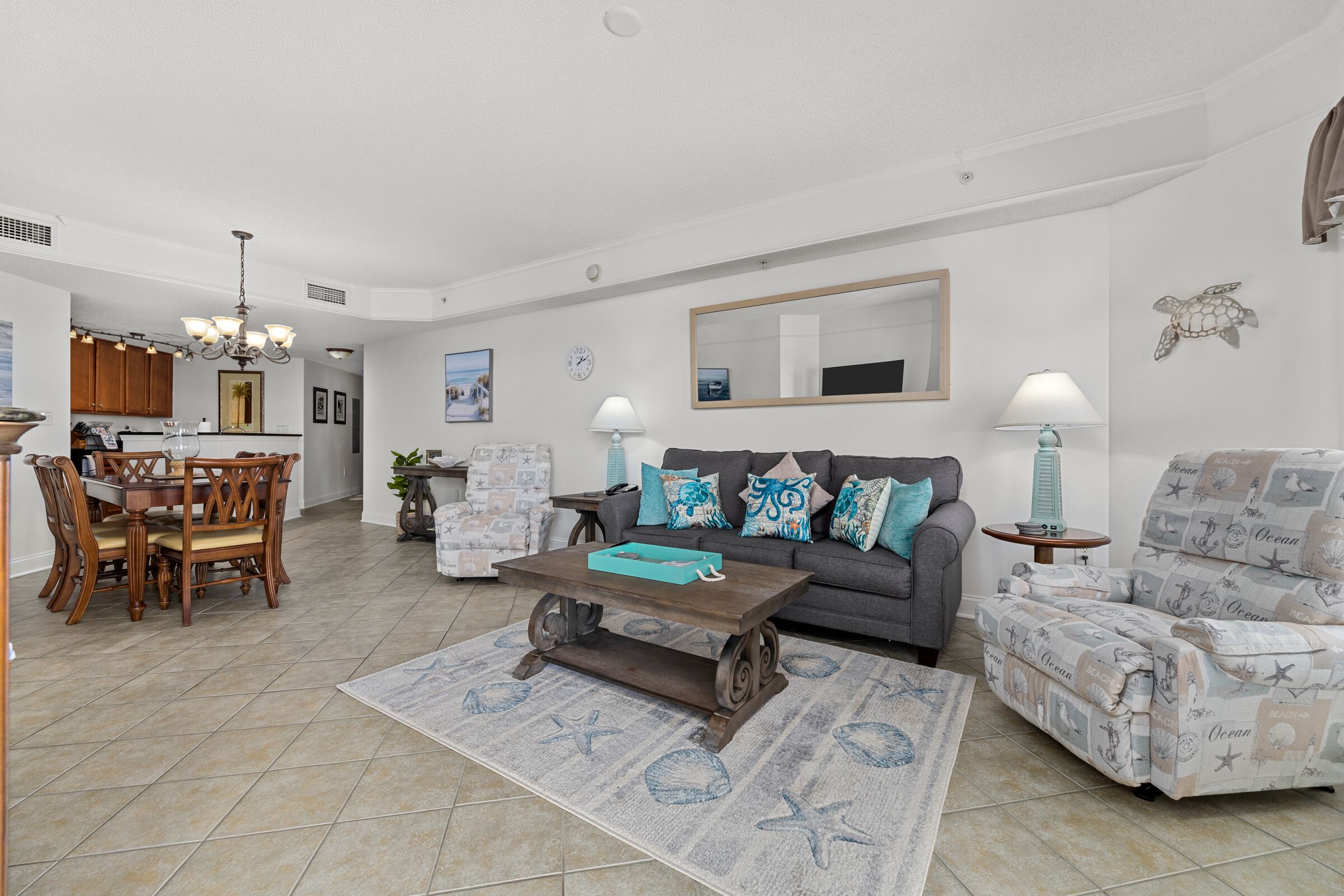 Una sala de estar con sofá, mesa de centro y alfombra estampada.