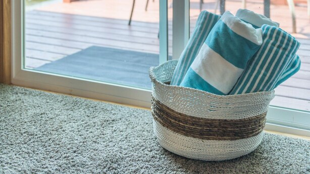 A view through a glass door to a deck with outdoor furniture, a wooden railing, and a body of water in the background. - Lakefront Cozy Cabin w/ Dock; 2 BR- 1BA, One Hour from the Twin Cities (Lindstrom)