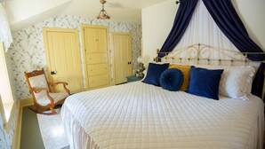 Ein Schlafzimmer mit einem Bett, einem Schaukelstuhl und zwei Türen.