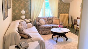 Ein gemütliches Wohnzimmer mit einer Couch, einem runden Couchtisch und einer Heizung.